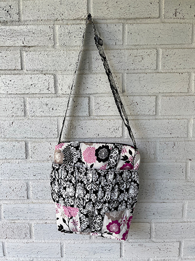 Small floral damask cross body doll carrier front view